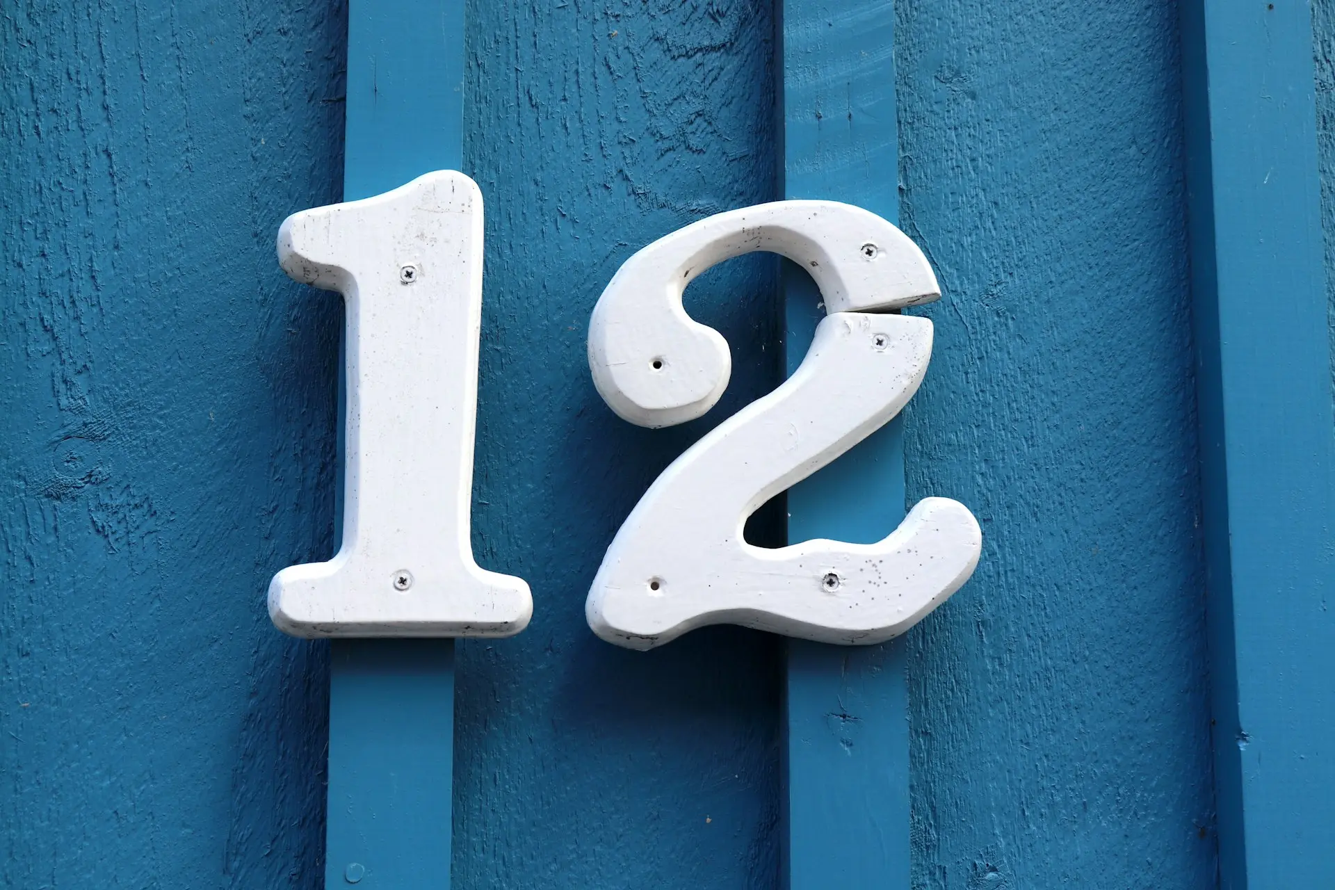 A white house number on a blue door